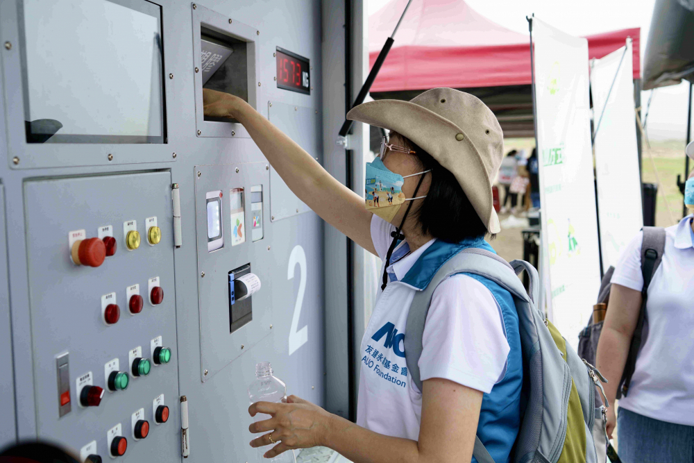 志工們將拾起的寶特瓶投入「好歸塑專車」，讓廢棄塑料空瓶可以直接粉碎、縮小體積，未來將可再製成購物袋、寶特衣、悠遊卡等生活用品